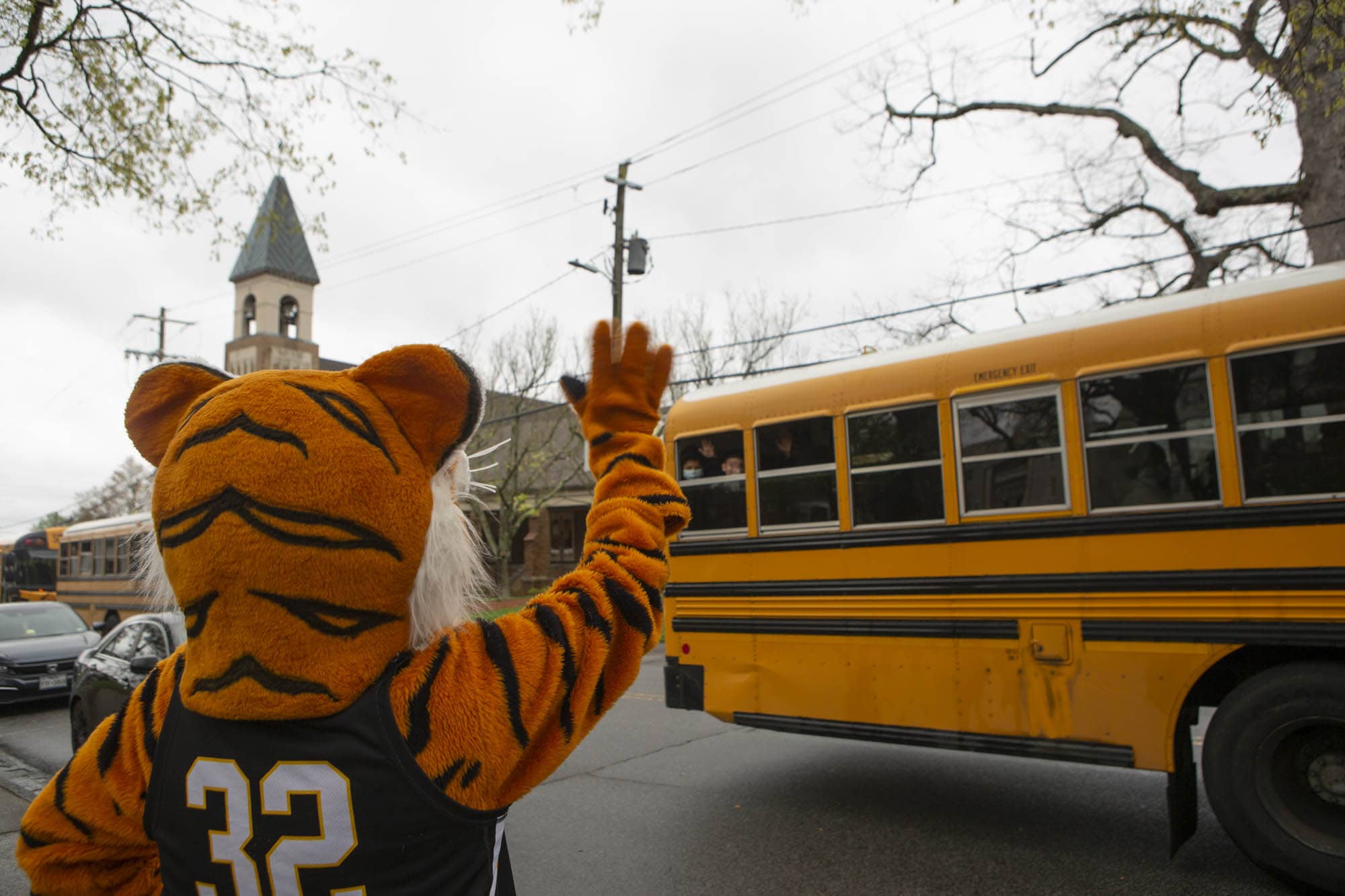 Costumed tiger waves at school bus