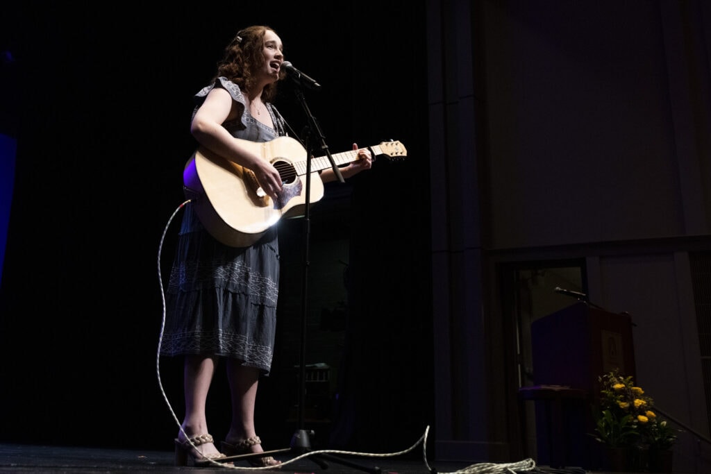 singer with guitar on stage for Women's Leadership Colloquium
