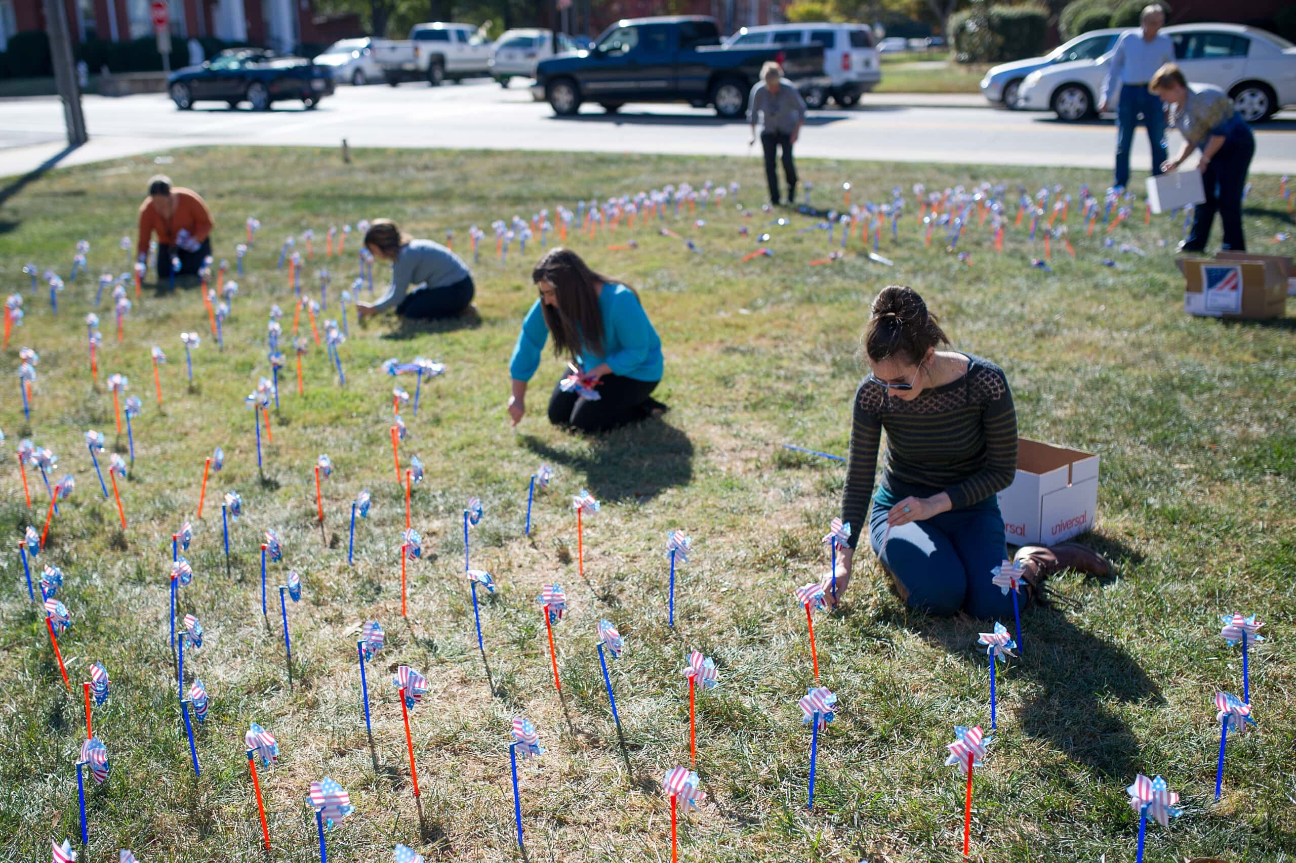 Students, faculty and staff place pinwheels in front of Owens Student Center.