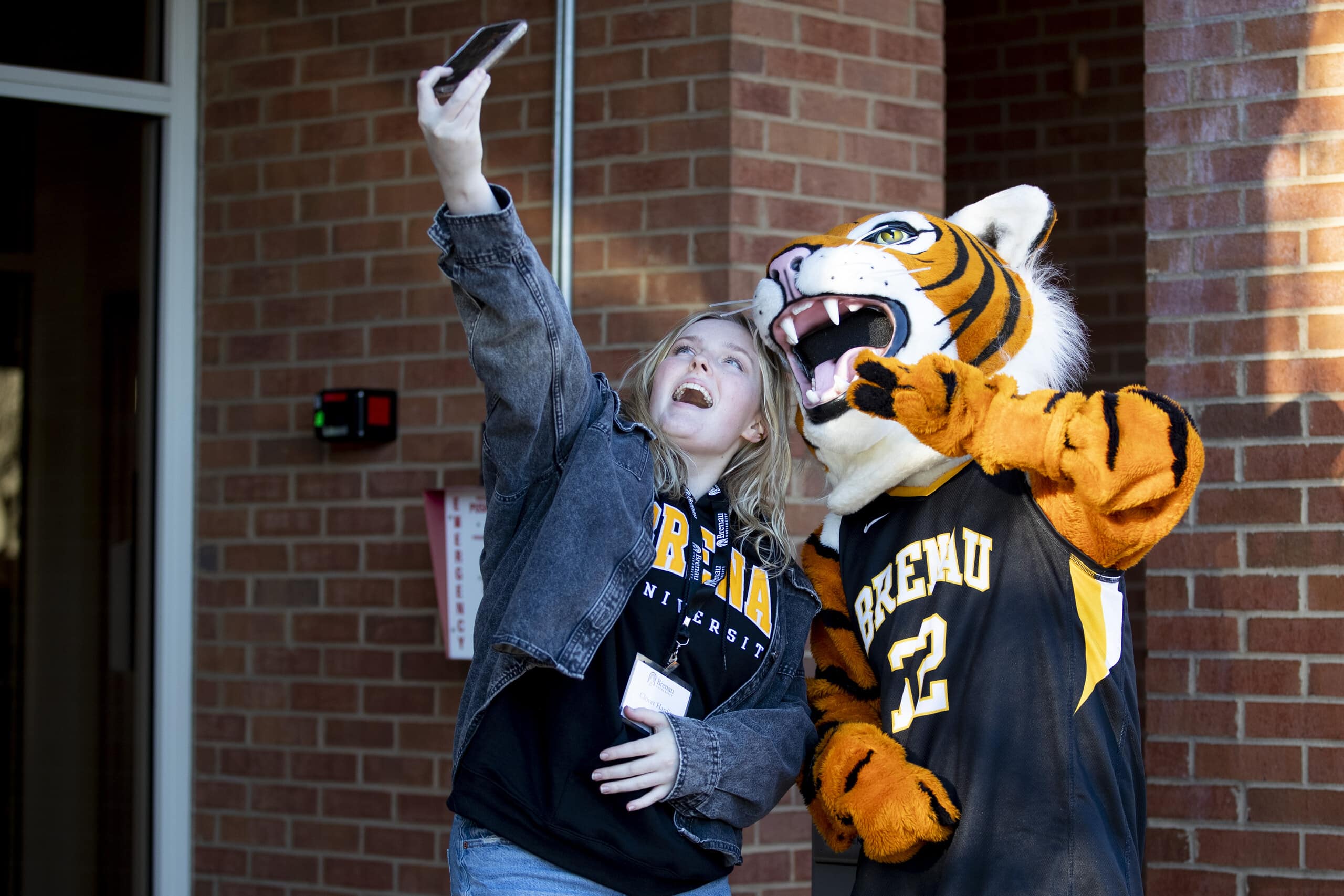 student takes a selfie with Brenau mascot