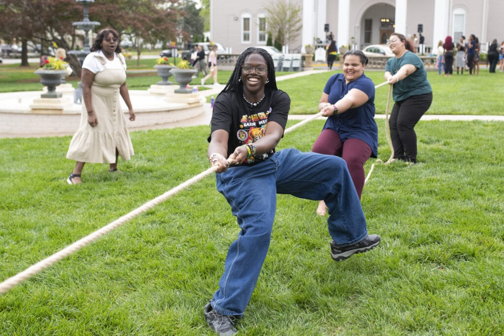 Students play tug of war on the front lawn
