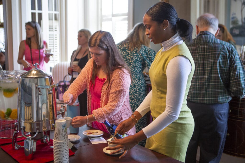 women get beverages and snacks from a table