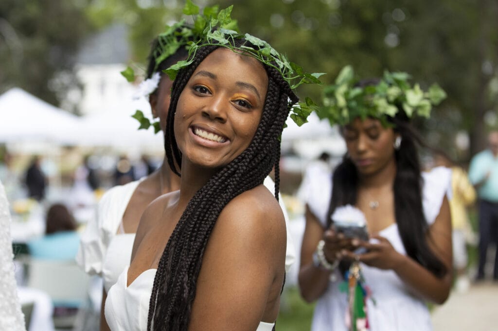 smiling young woman in white dress with ivy crown