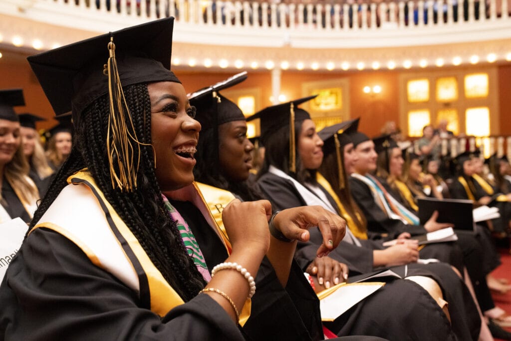 A graduate smiles at The Women's College commencement ceremony