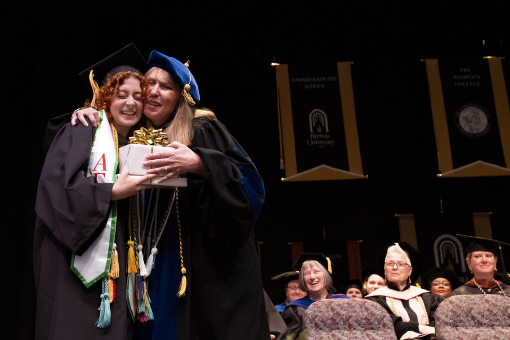 A Women's College graduate hugs Dean of the Women's College Dr. Debra Dobkins