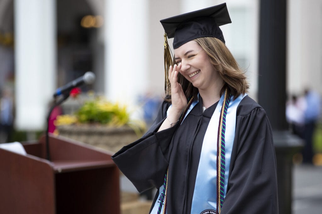 A university graduate wipes away a happy tear as she collects her diploma