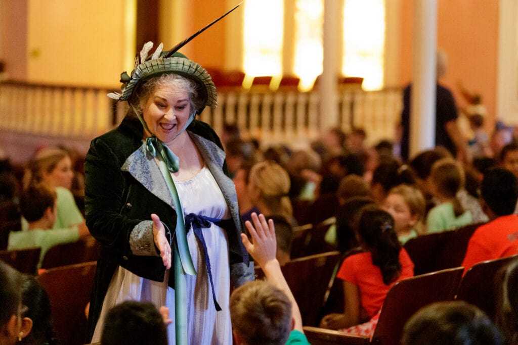 Gay Hammond high-fives a student in the audience of one of her WonderQuest shows.