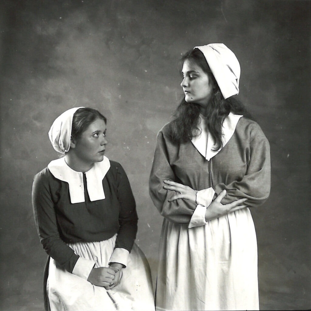Gay Hammond, as Abigail, peers down at another character in a promotional image for The Crucible.