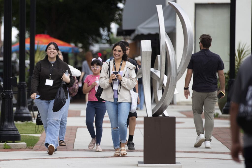 Students wearing their name tags walk around the downtown campus.