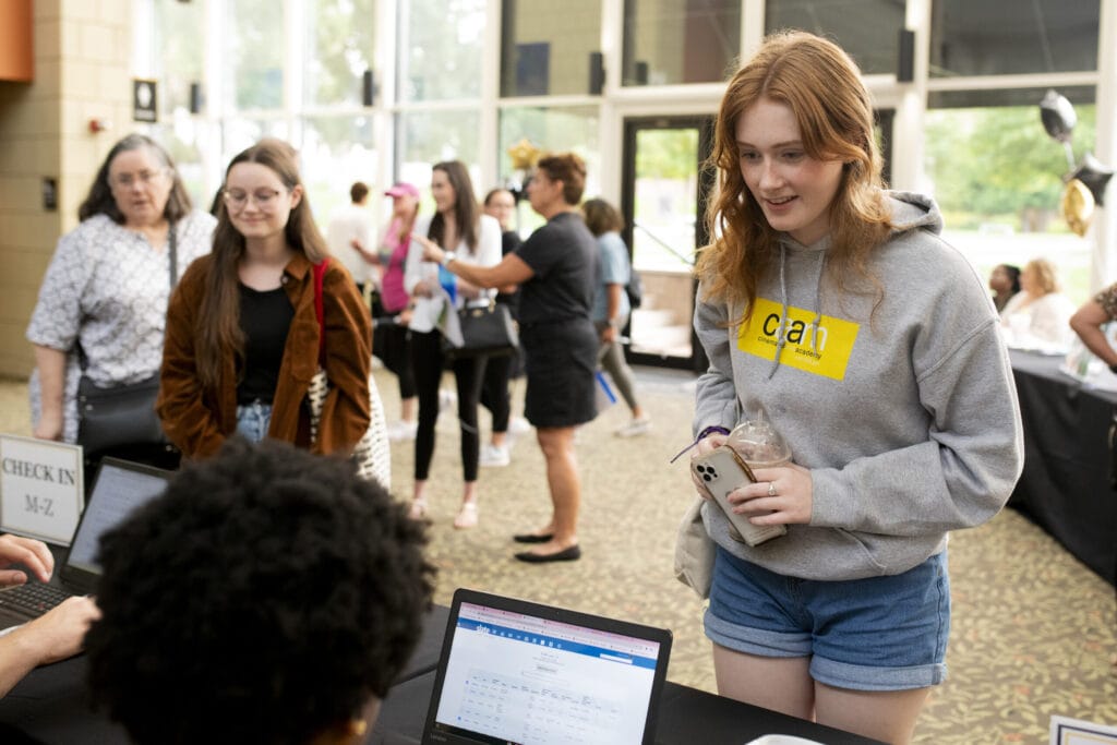 A female student checks in at registration.