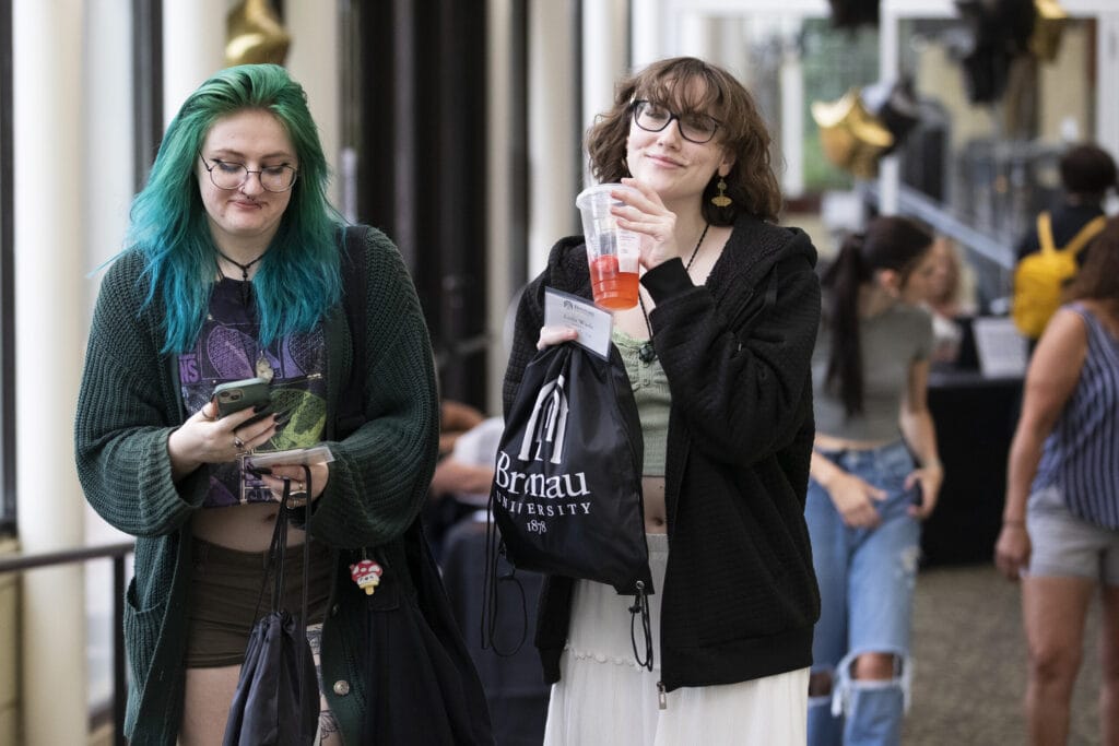 Two female students hold their Brenau swag bags.