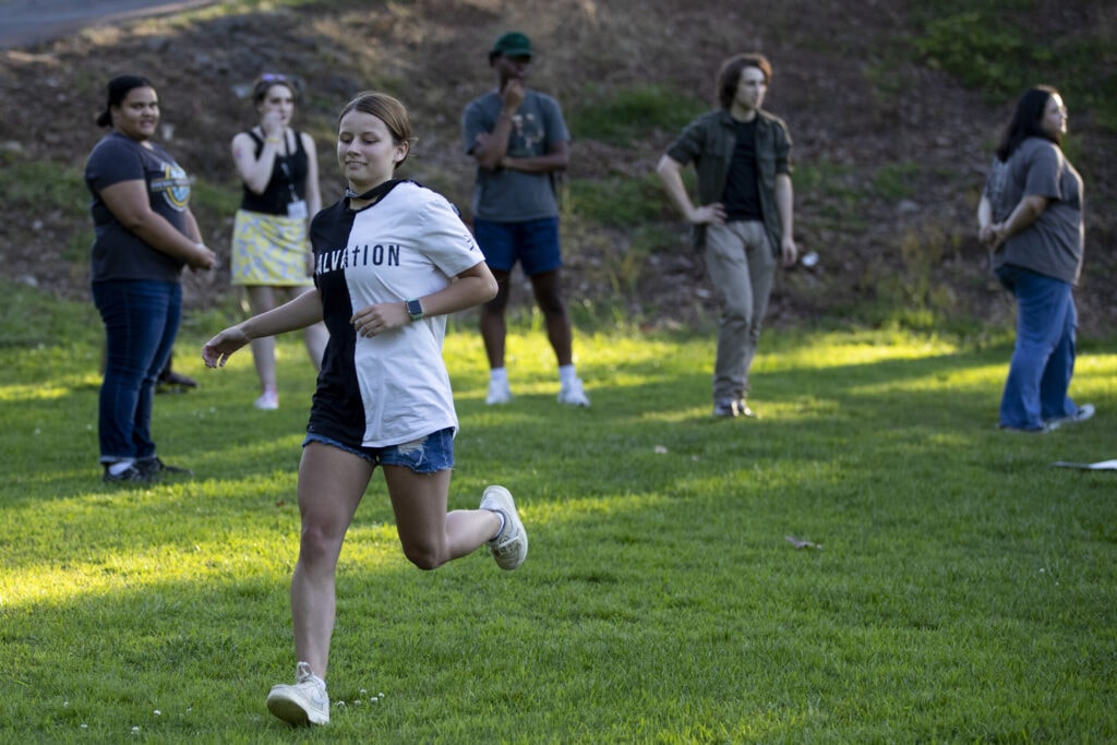 A new student runs as part of a field game.