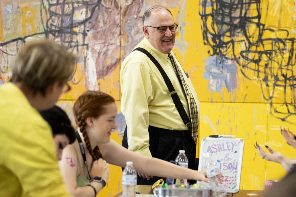 A male professor oversees an activity for new students.