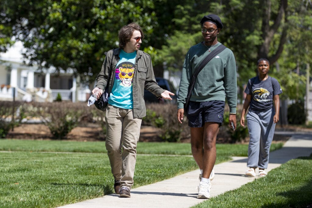 Two male students talk as they walk around campus