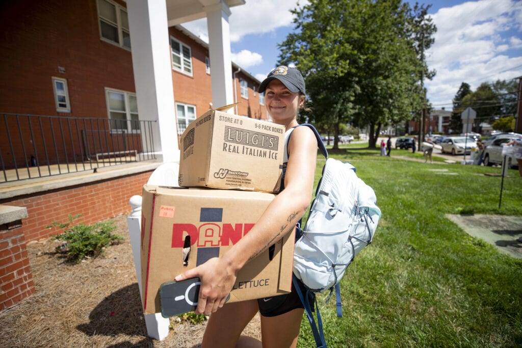 A Brenau athlete tests her strength carrying multiple boxes on move in day.