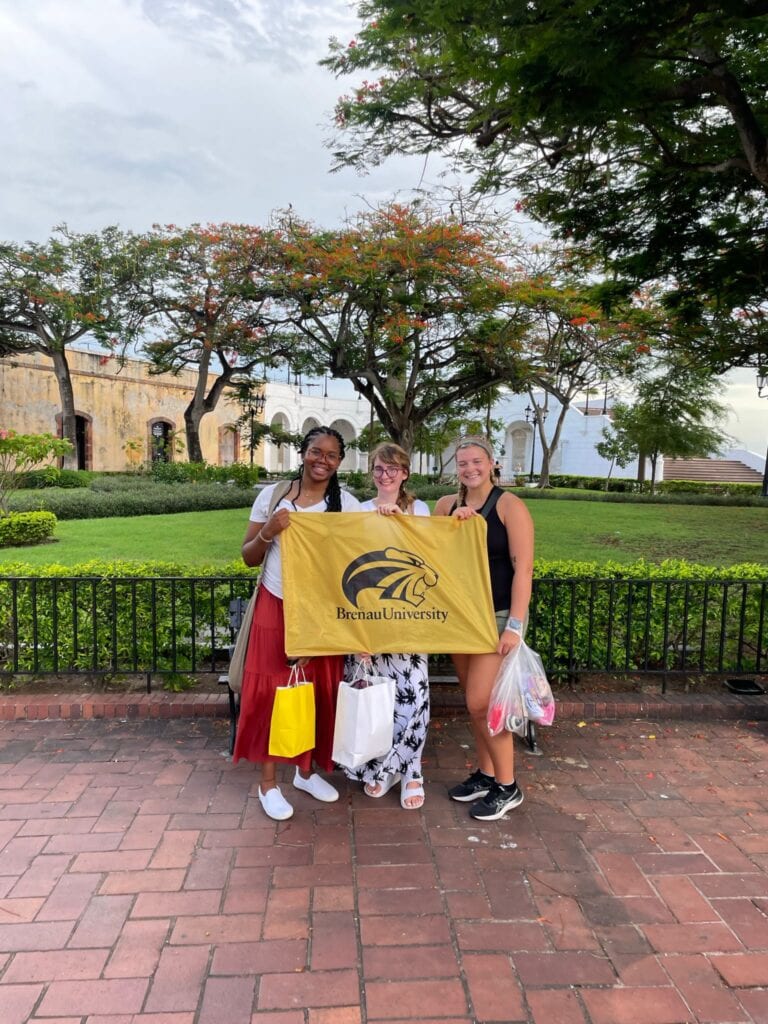 Brenau students hold a school flag in Panama