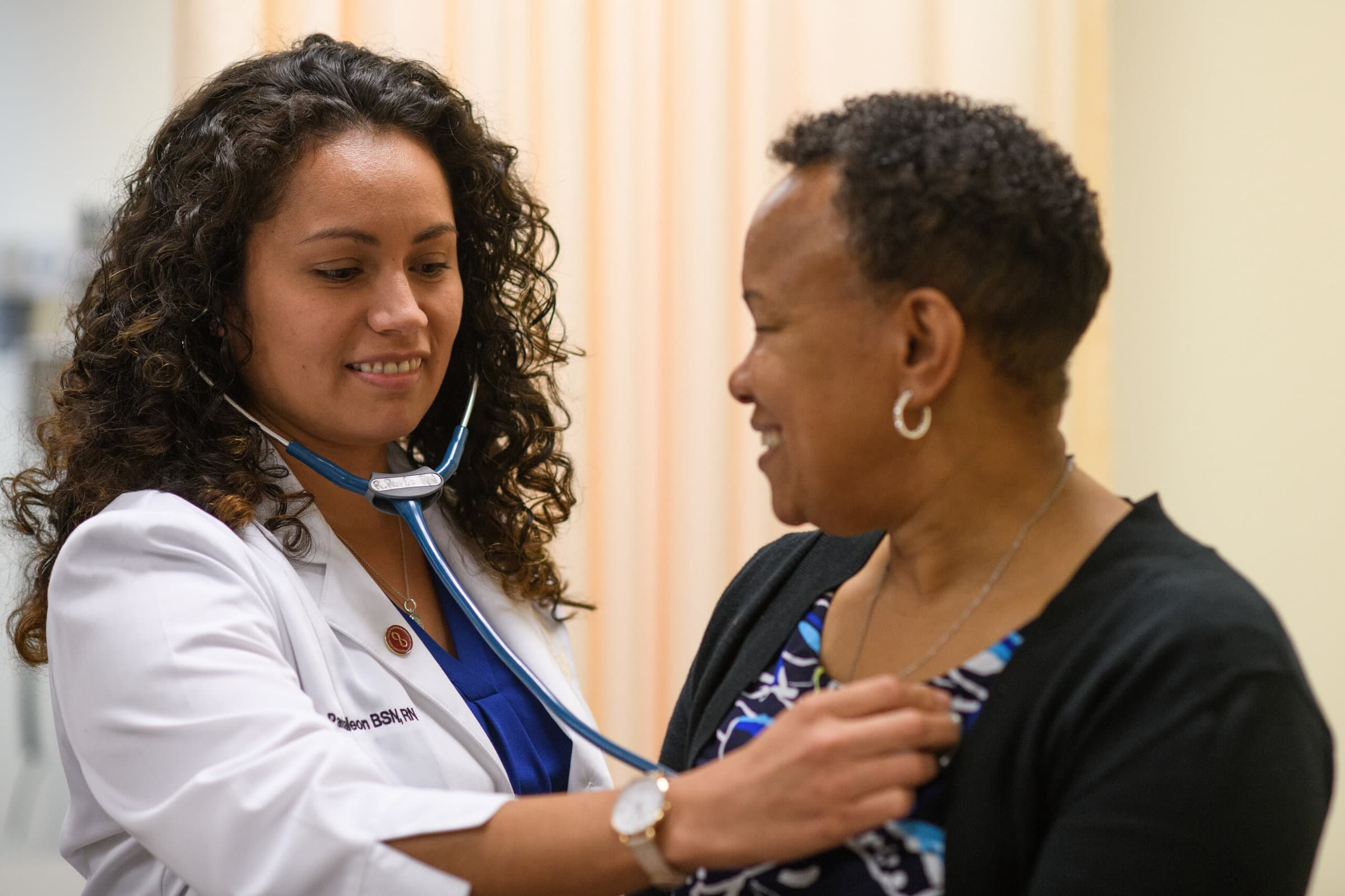 Woman in white coat perform examination with a stethoscope on a patient