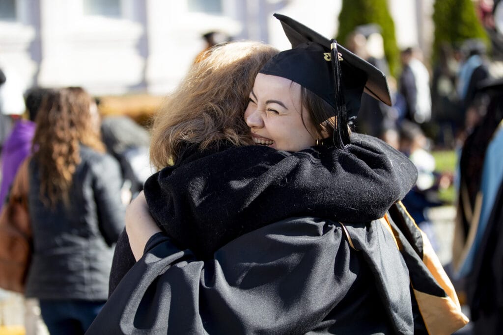 A graduate hugs a family member after the ceremony