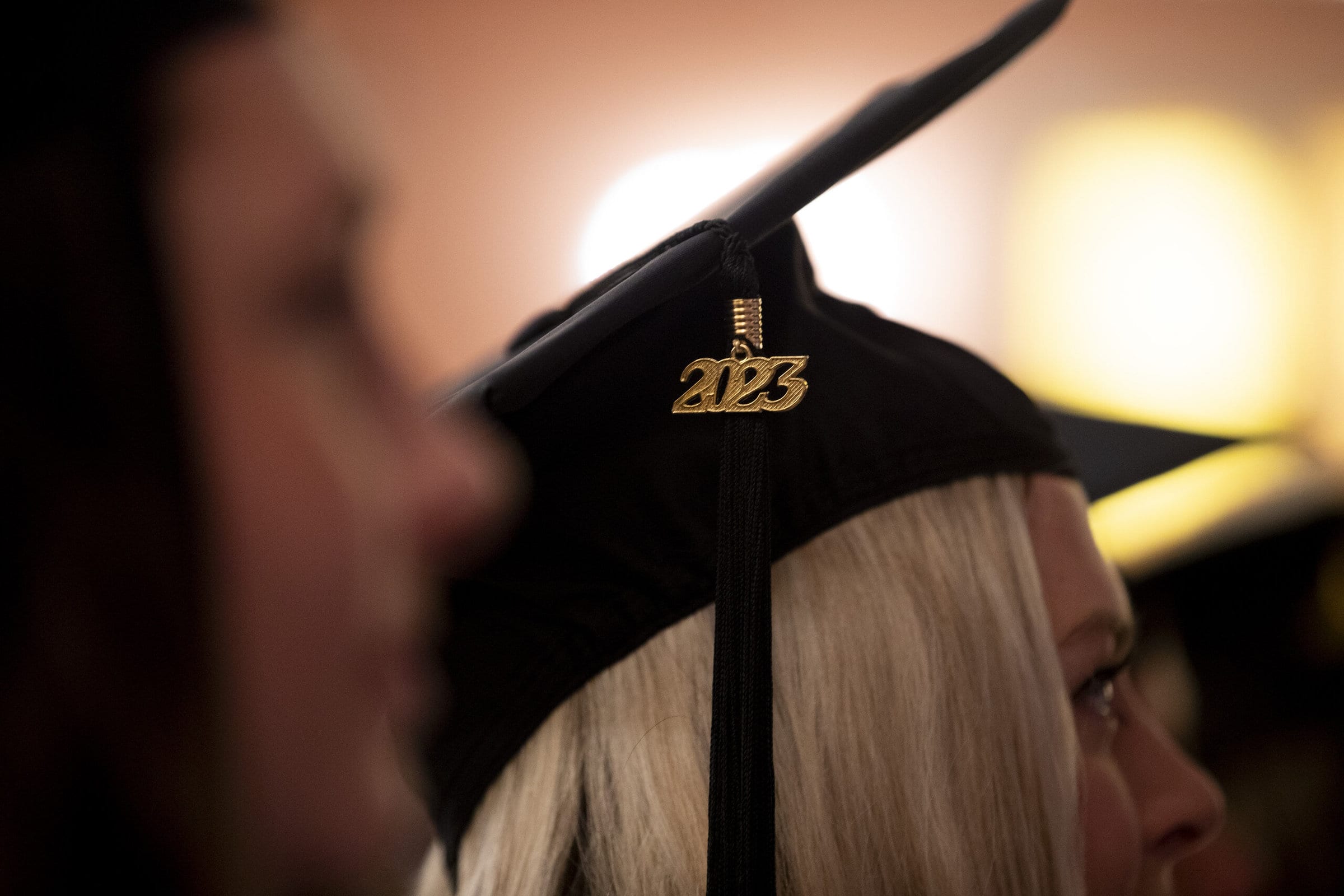 The 2023 charm dangles from a motorboard at the the 2023 winter commencement ceremonies.