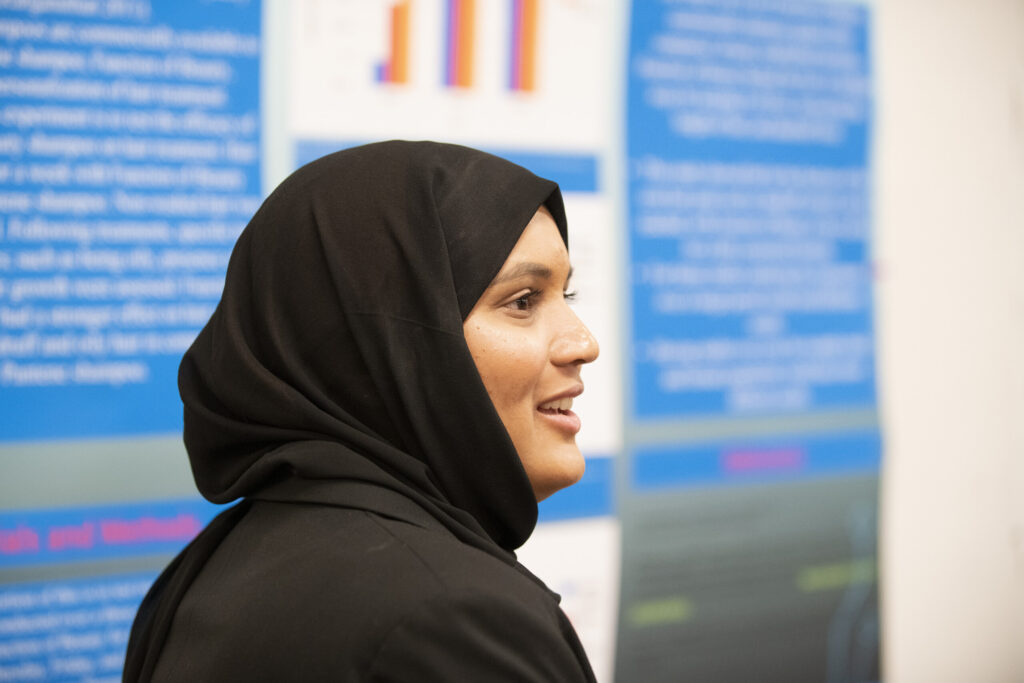 A woman presents at the research symposium