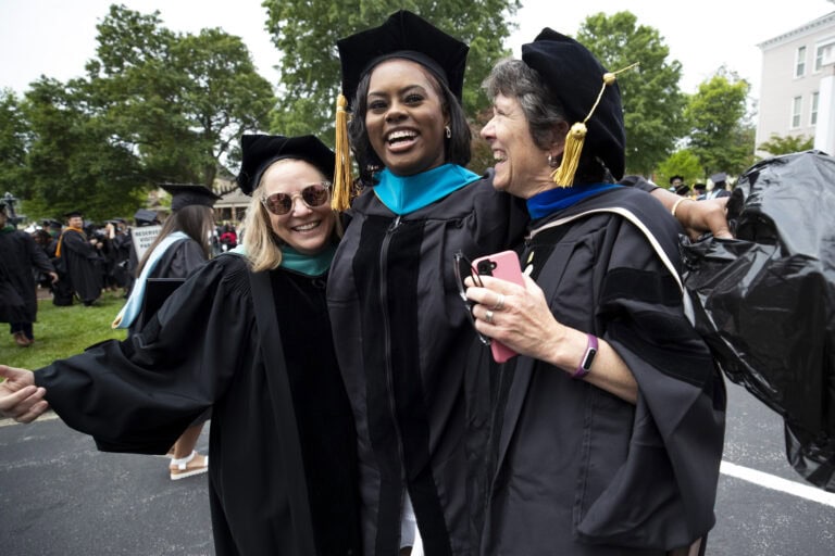 A doctoral graduate and two of her professors celebrate after she was awarded her degree in spring 2023.