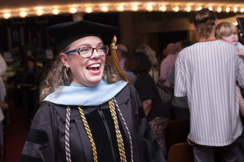 Dr. Mandy Bartell, a member of Brenau's staff, smiles as she heads to the stage to give the invocation.