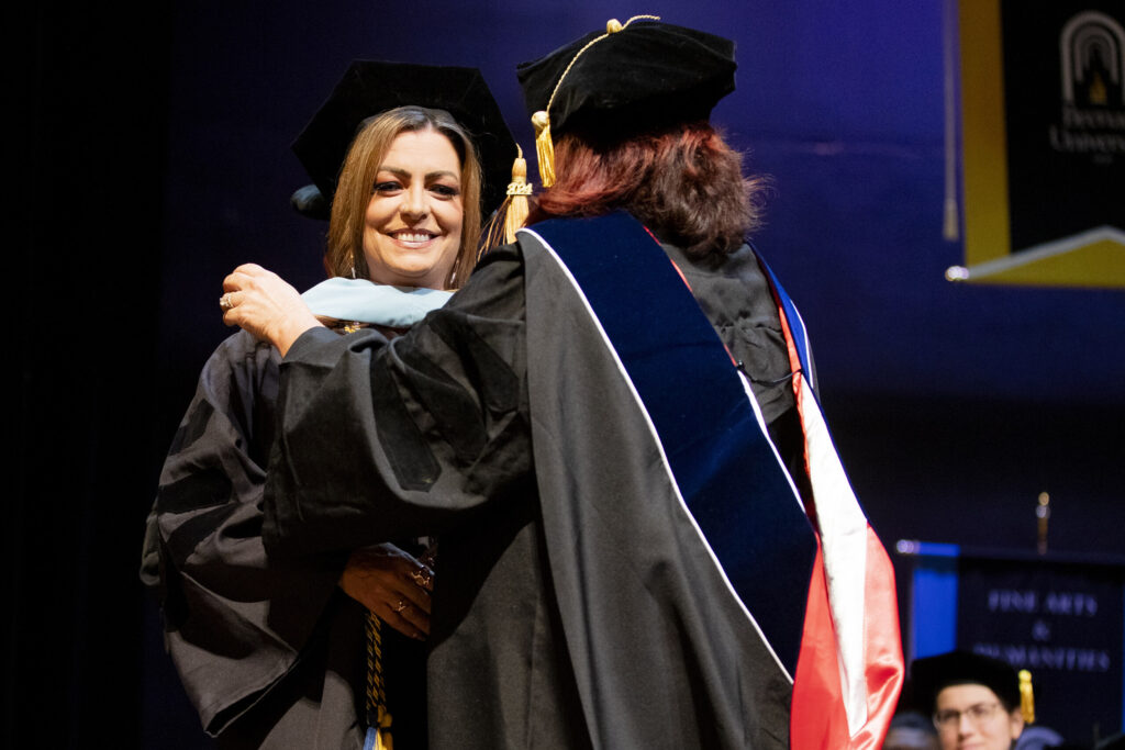 Dr. Jamie Cushway is hooded during her doctoral graduation ceremony