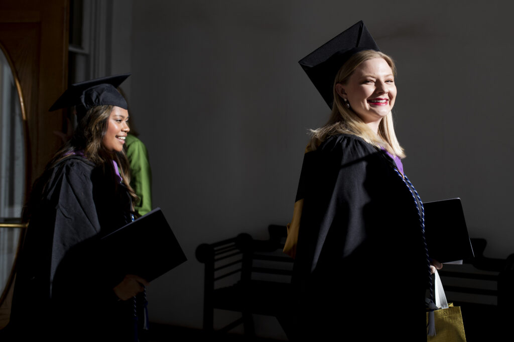 Two graduates walking on campus