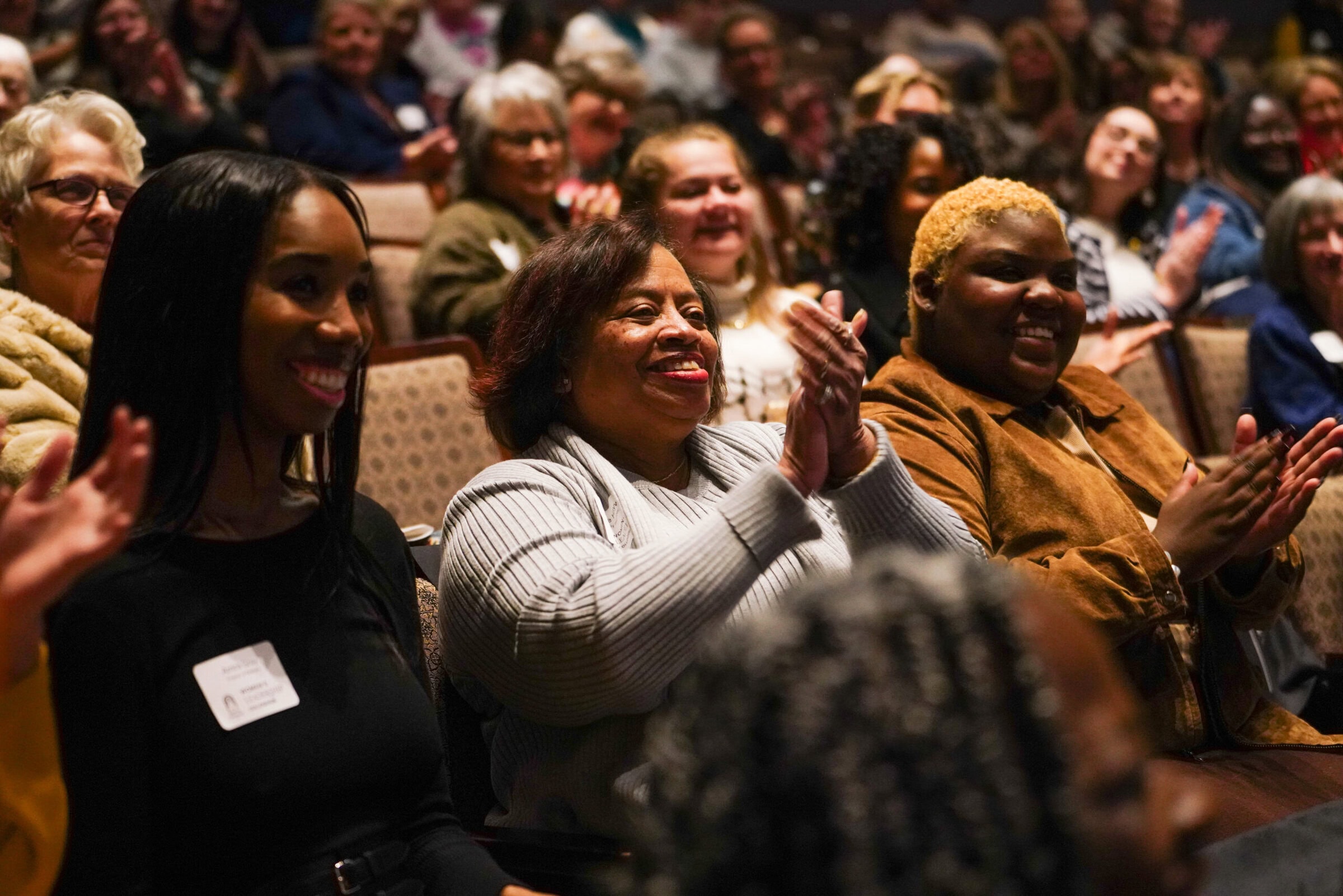 women clapping in the audience