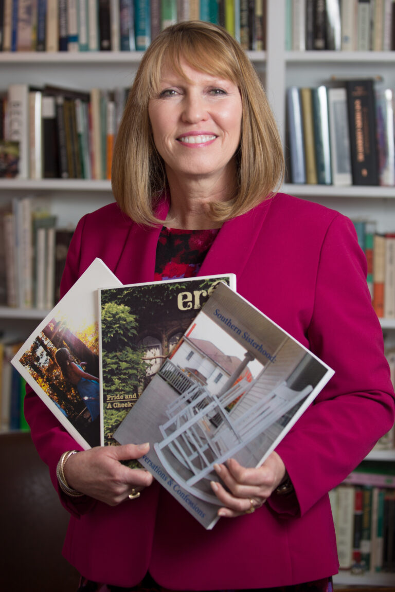 Debra Dobkins, dean of The Women's College, poses with magazines created over the last 16 years by her students.The students spend three weeks refining literary critiques from throughout the semester, conceptualizing and designing a magazine as a class.