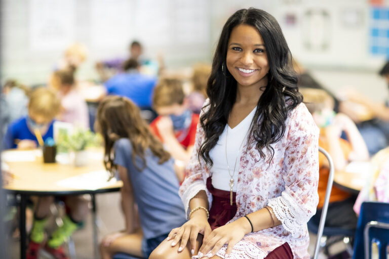 Teacher sits in classroom with students