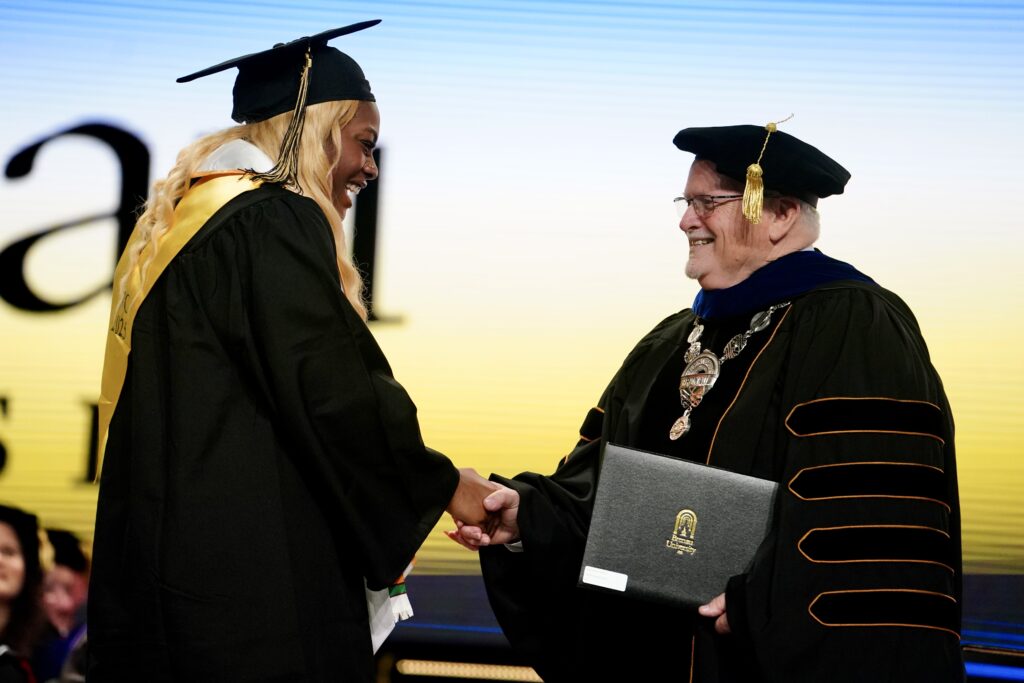 a Women's College graduate shakes Dr. Barentt's hand