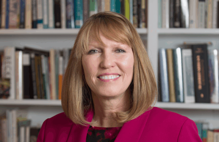 Dr. Debra Dobkins in front of her bookshelves