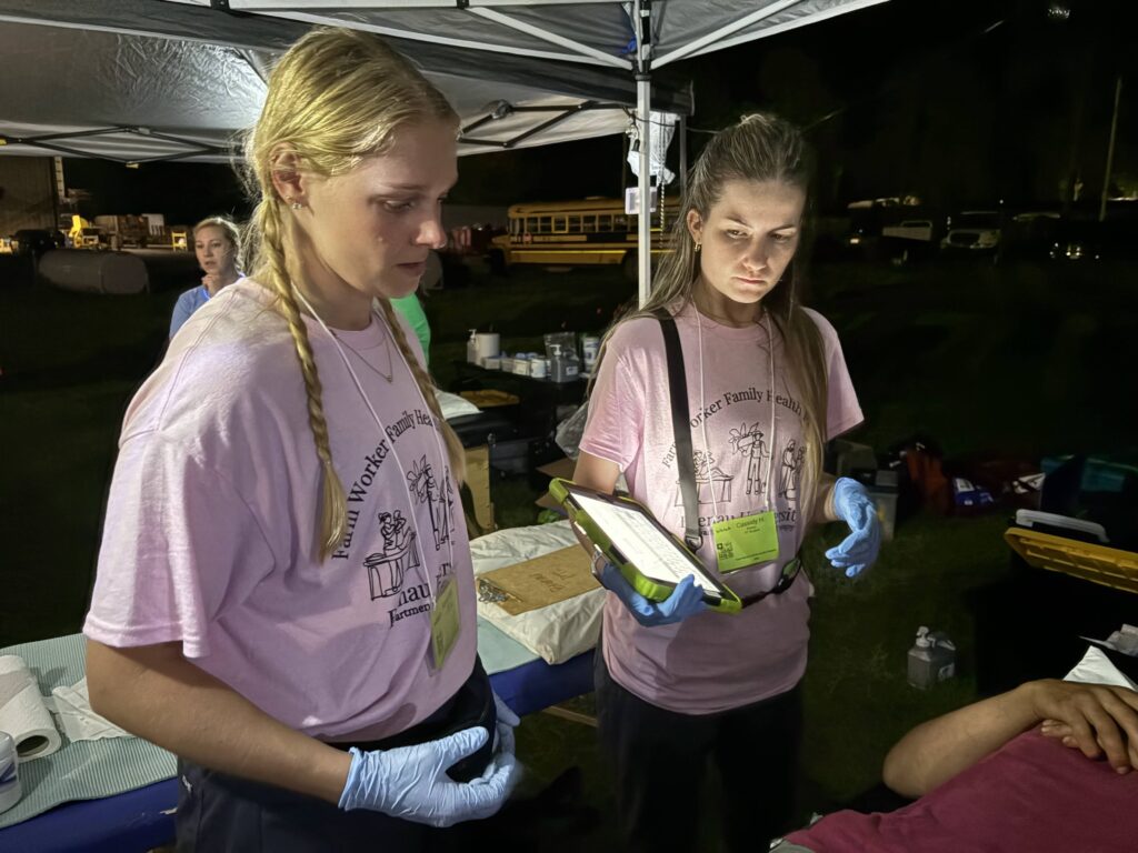 Two PT students with an iPad working in the evening