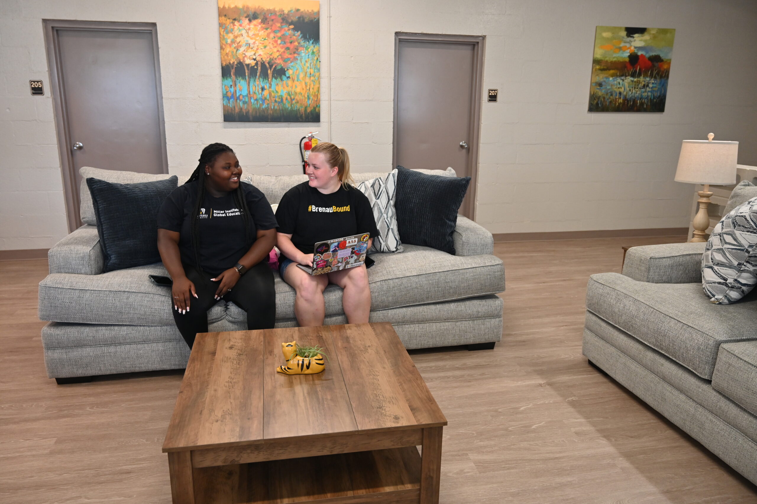 two students laugh and chat in the new West Hall lounge