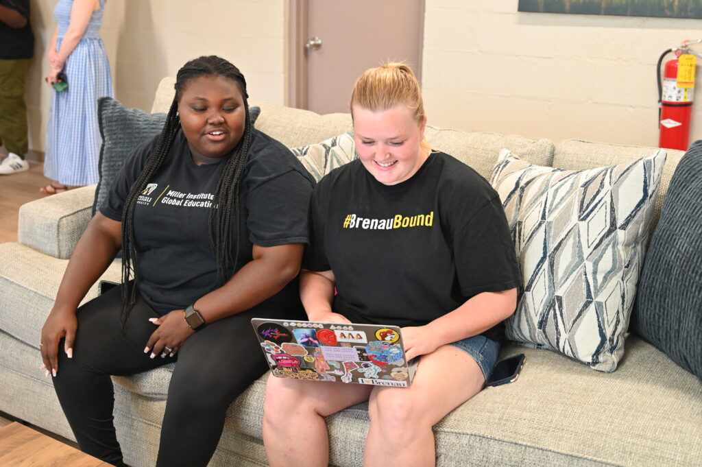 students Mercedes and Clover use a laptop in the lounge