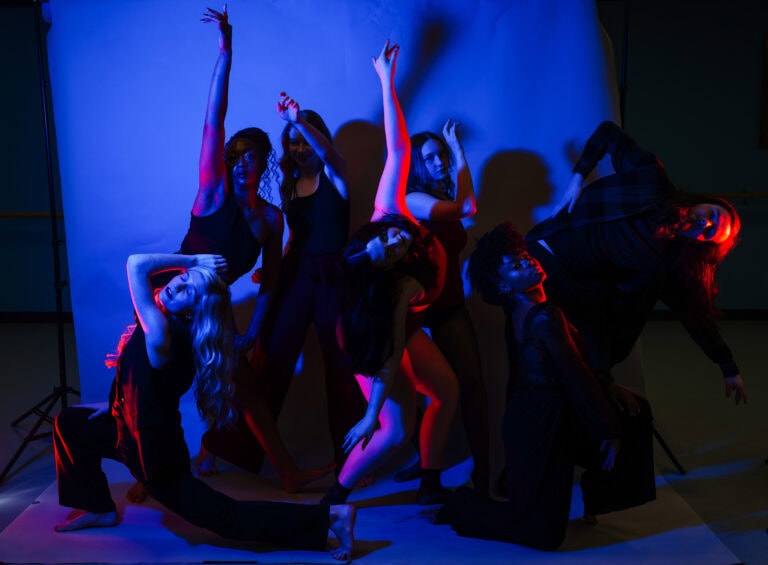 brenau dance students pose in front of backdrop