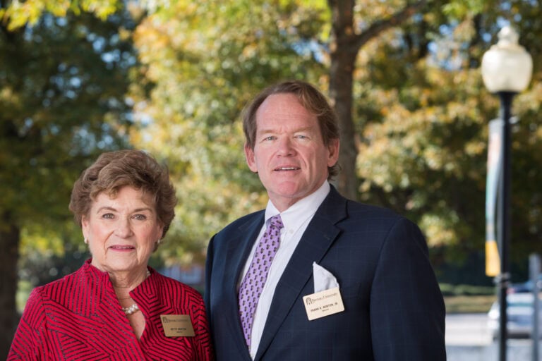 Retirees standing outdoors at Brenau University campus in fall.