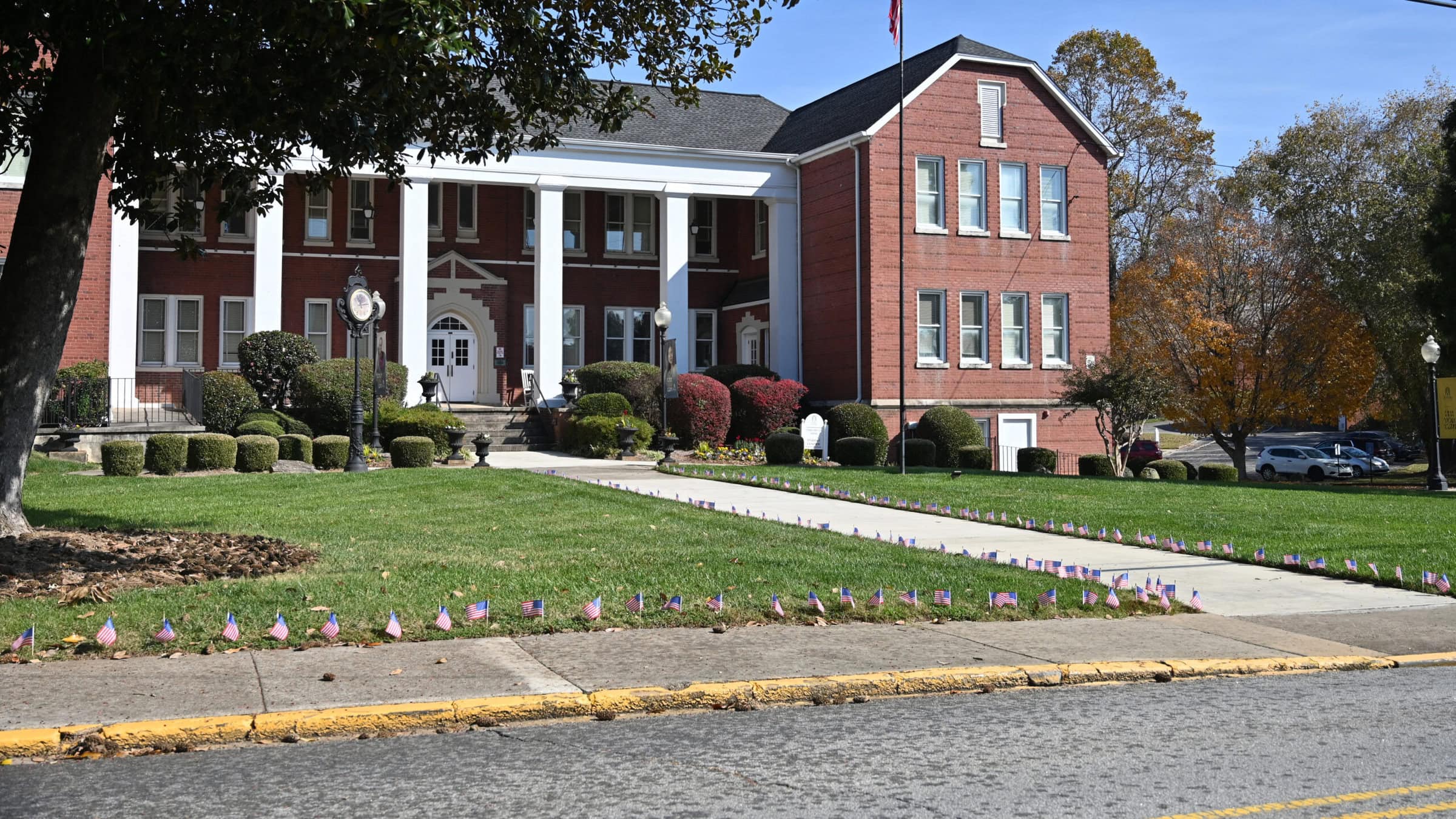 American flags decorating a sidewalk leading to Brenau University building in Georgia, showcasing campus pride and patriotic spirit.