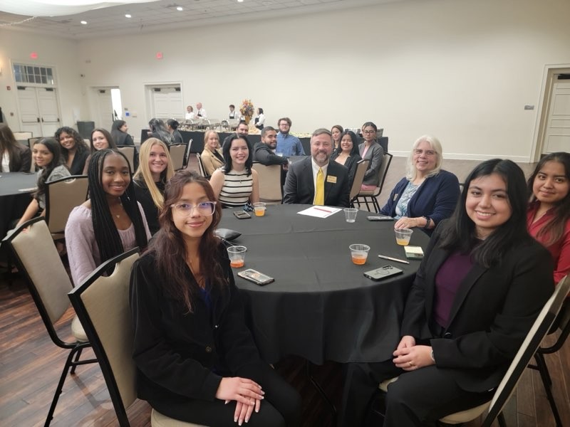 students and faculty at table at cpa night