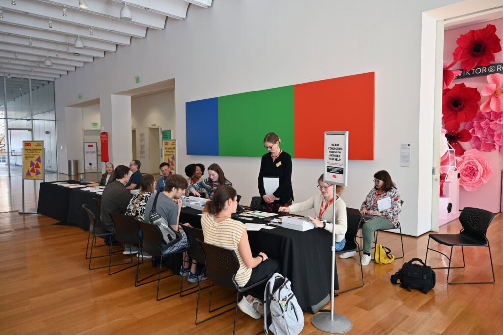 High-angle view of Brenau University admissions event with students and staff at registration desk in modern campus lobby.