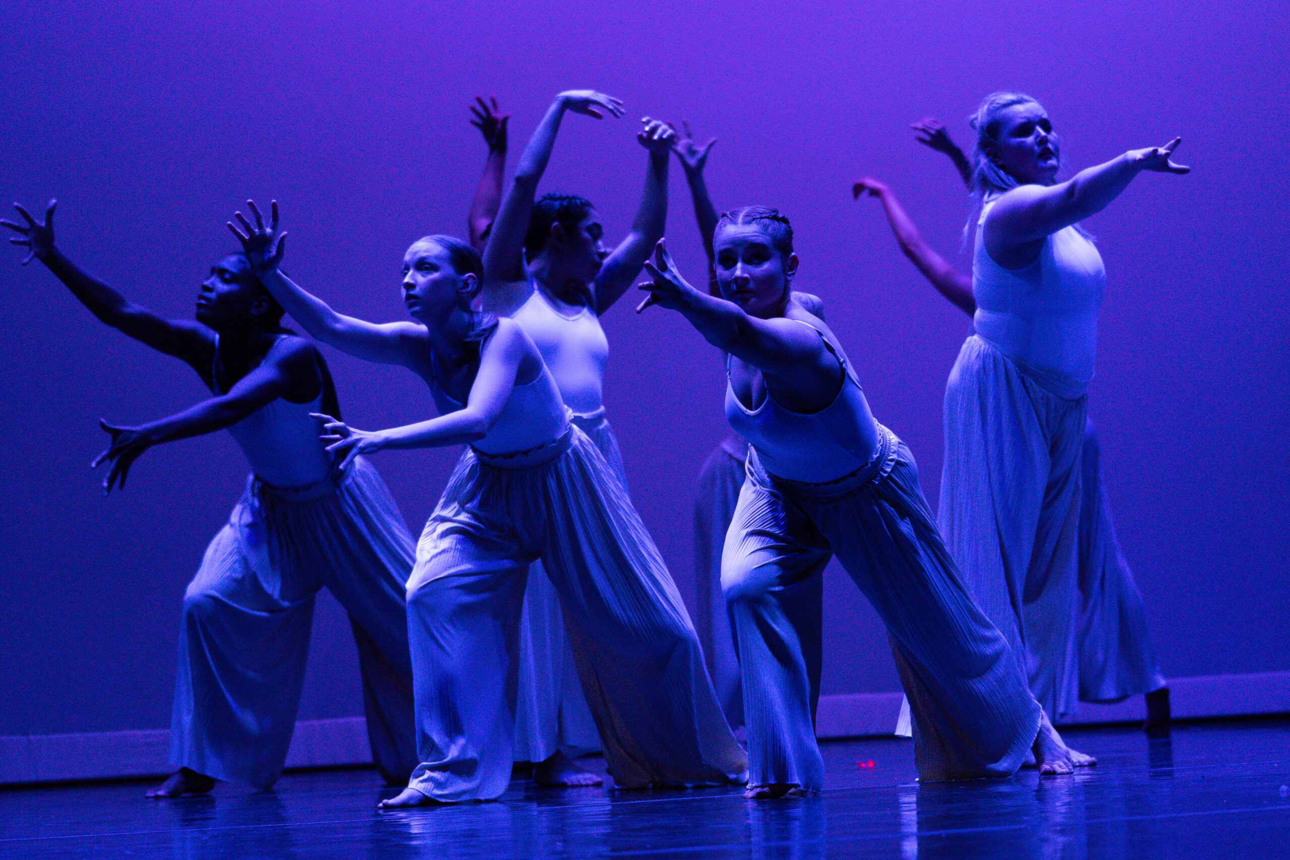 dancers in formation with blue stage lights