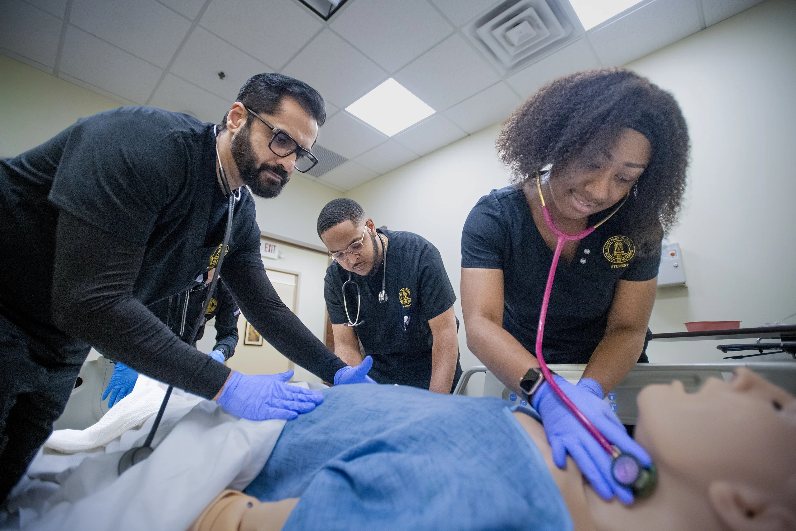 Nursing students practice on a simulation mannequin