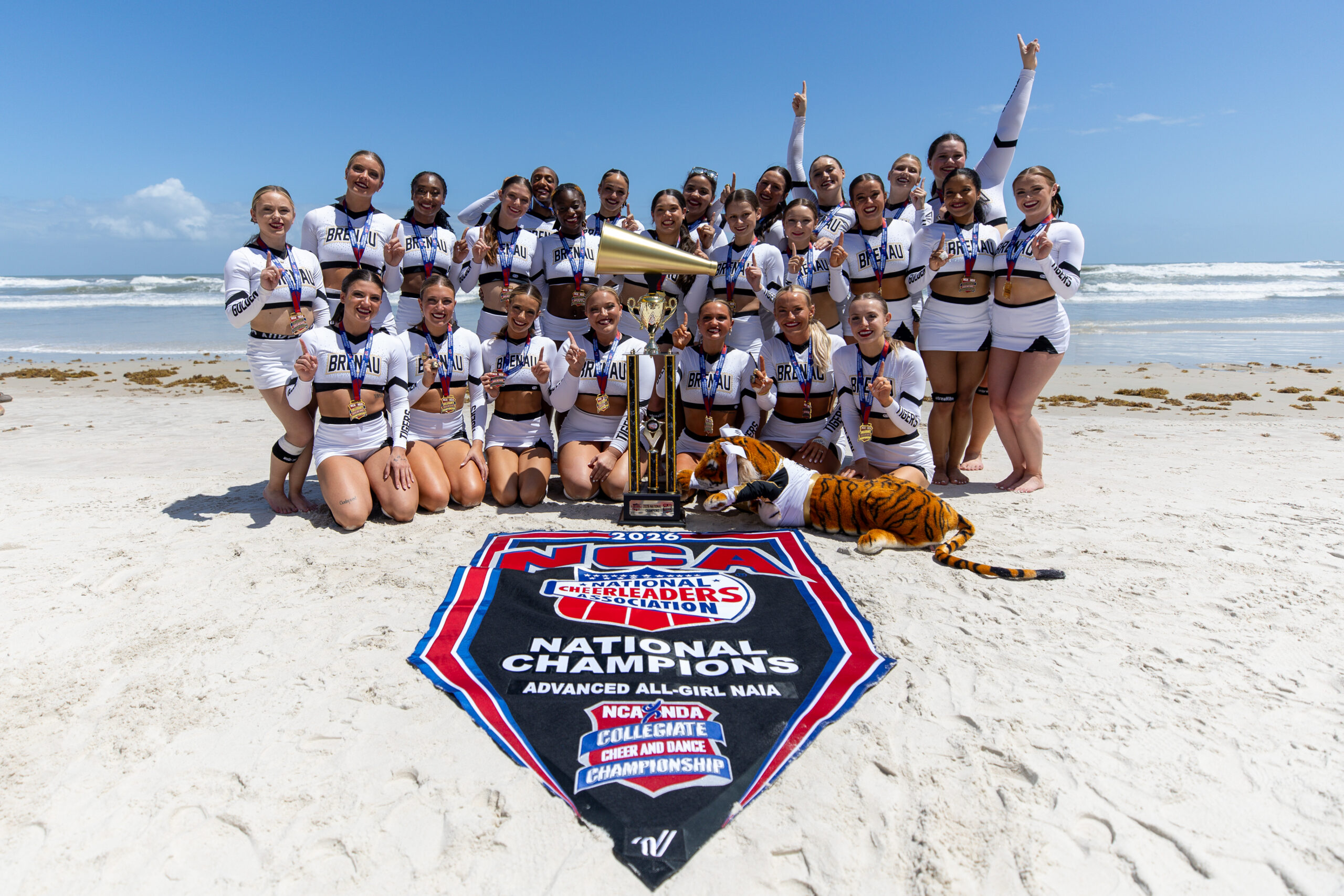 cheer team on beach with trophy an flag