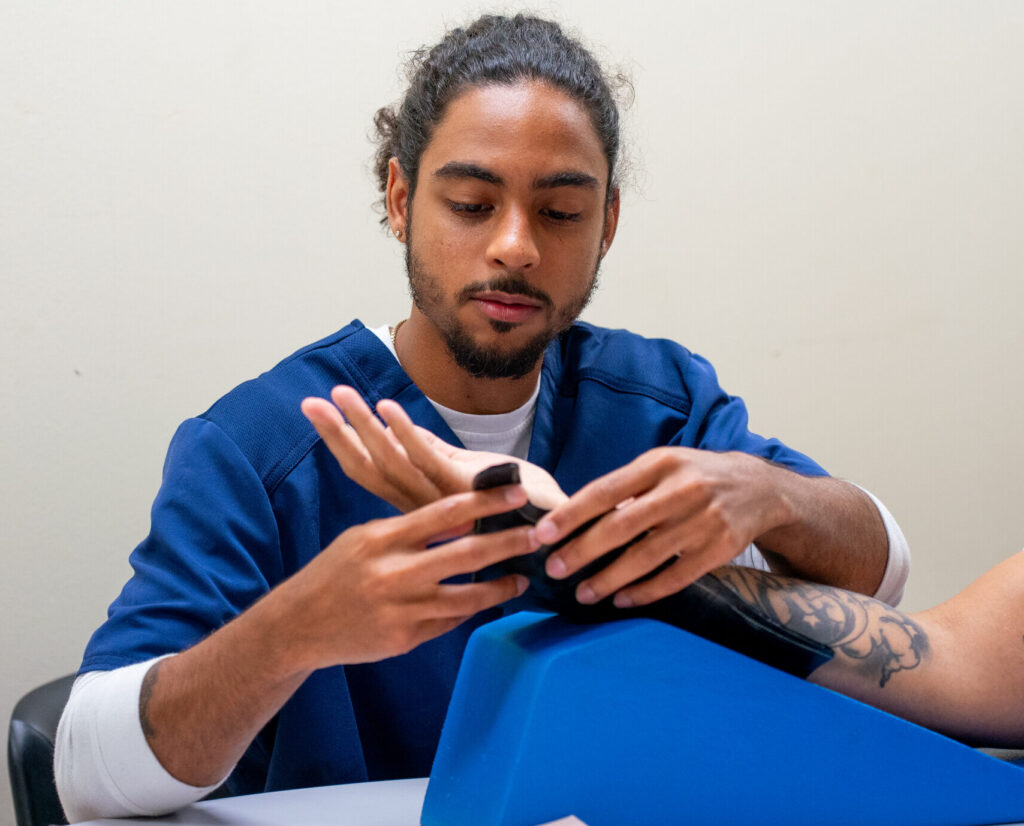 occupational therapy student examines a patient's hand