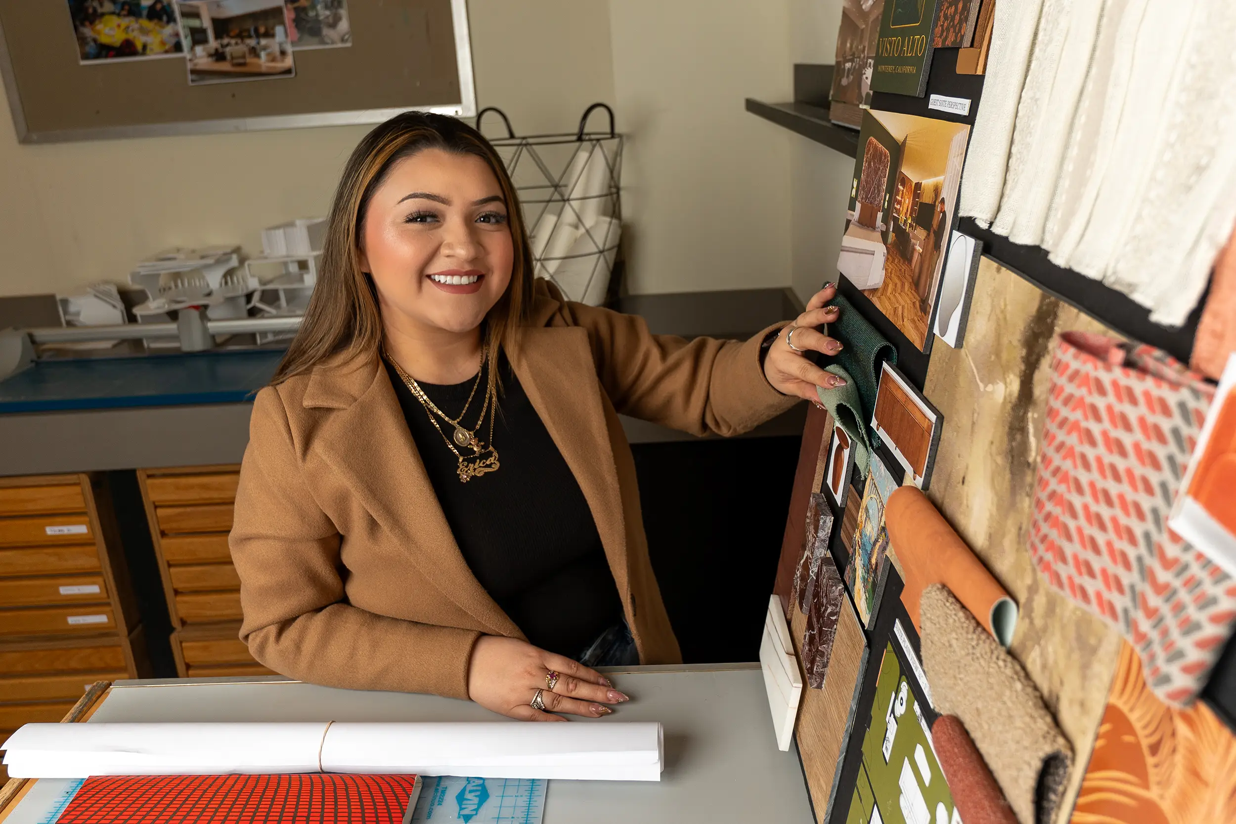 Interior design student stands in classroom.