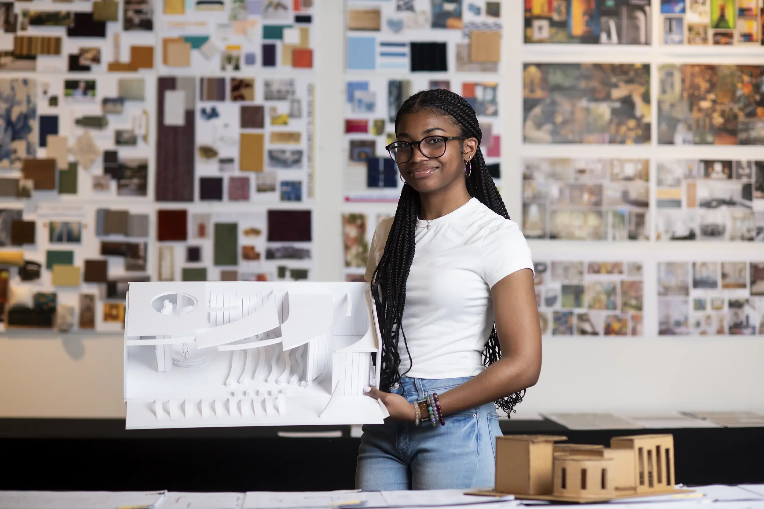 Interior design student holds model of a home.