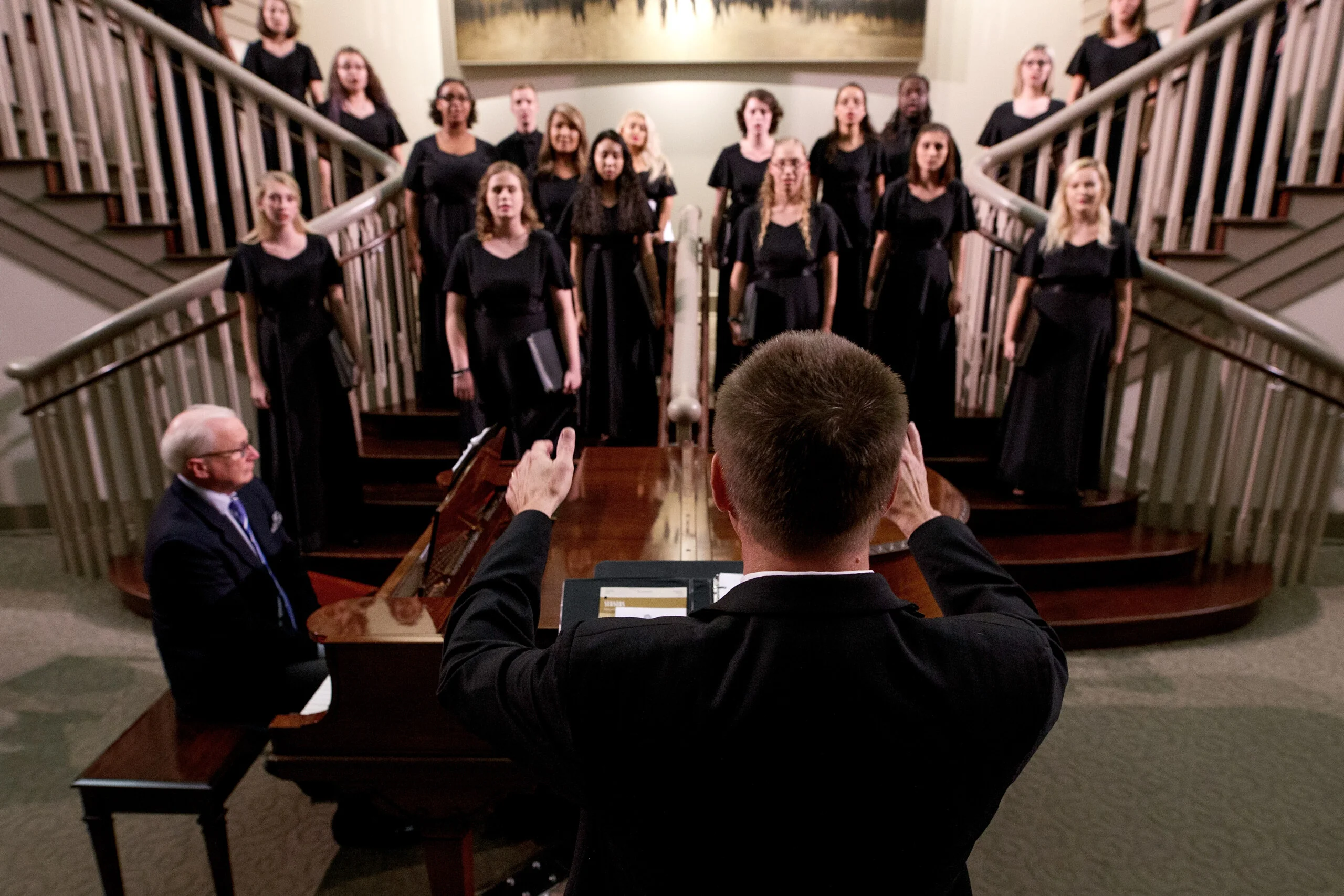 educator conducts a group of student singers
