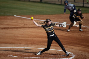 Brenau softball player in a black uniform pitcher in a softball field.