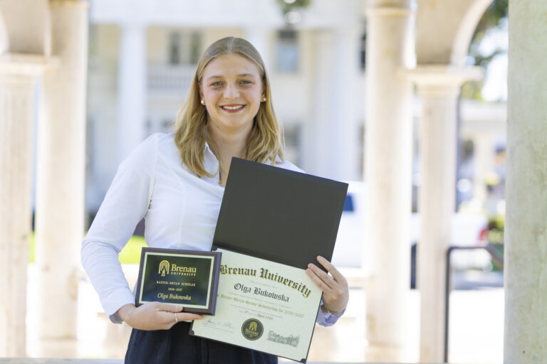 Olga Bukowska holds plaque and certificate for Baxter-Bryan award